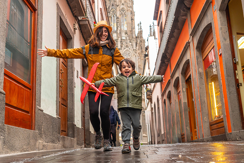 mom and child running through European streets laughing